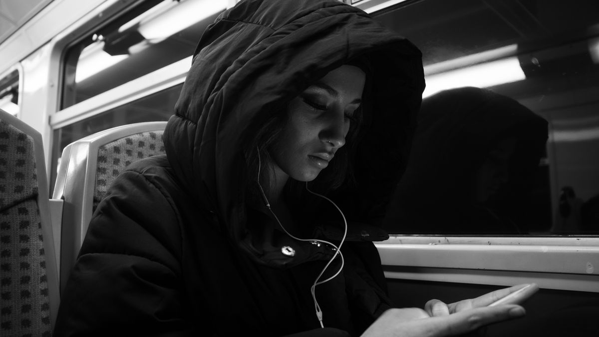 通勤電車でスマートフォンを使って勉強する人