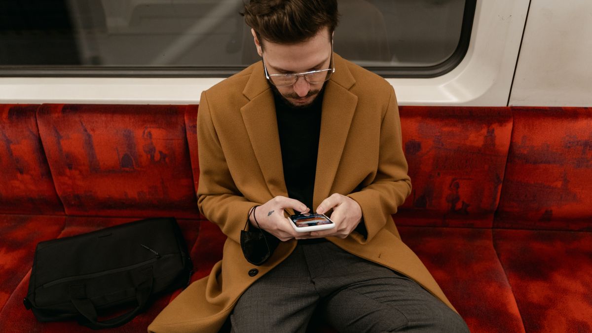 通勤電車内でスマートフォンを使いオンライン学習する様子