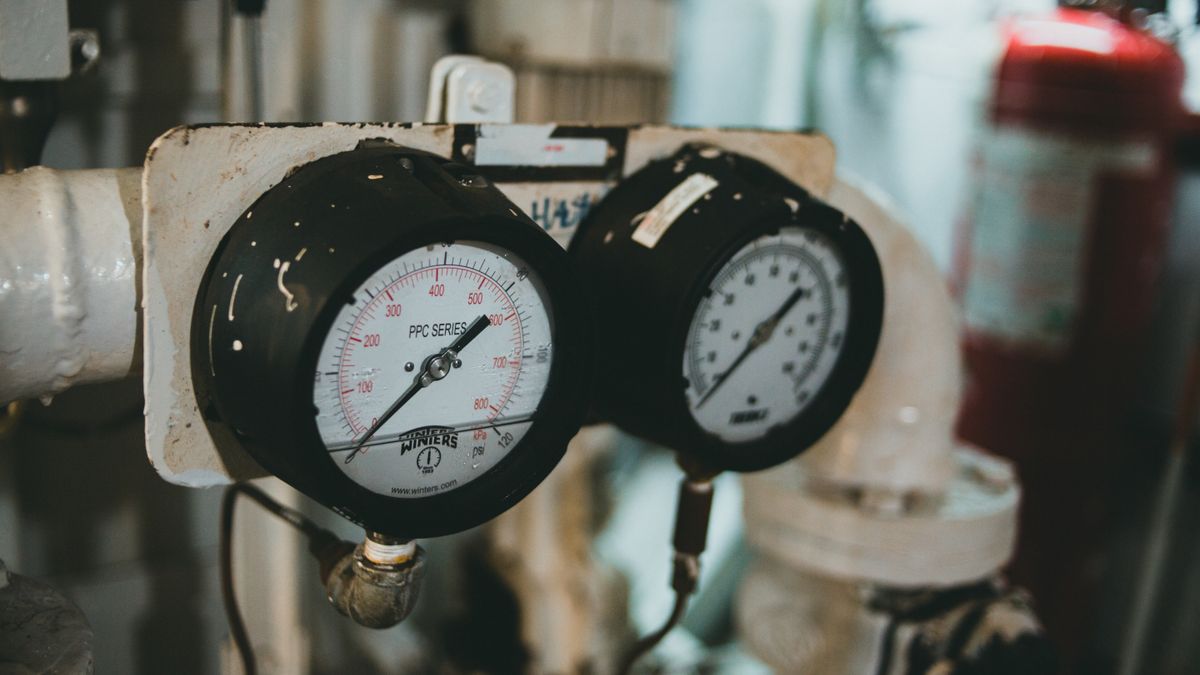 industrial engineer checking boiler pressure gauges in mechanical room