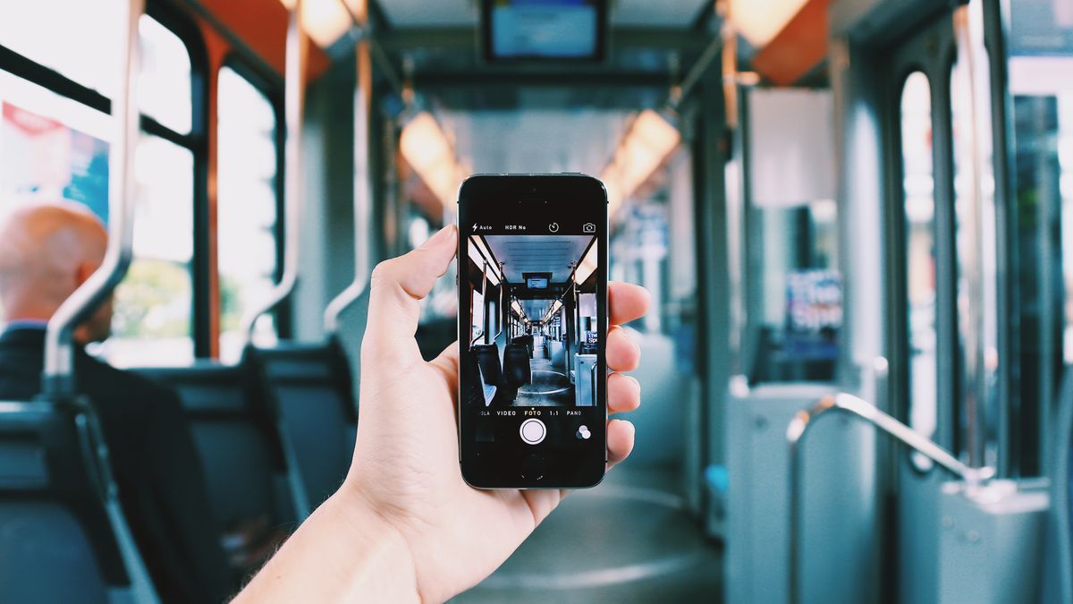 person studying smartphone app on train during commute