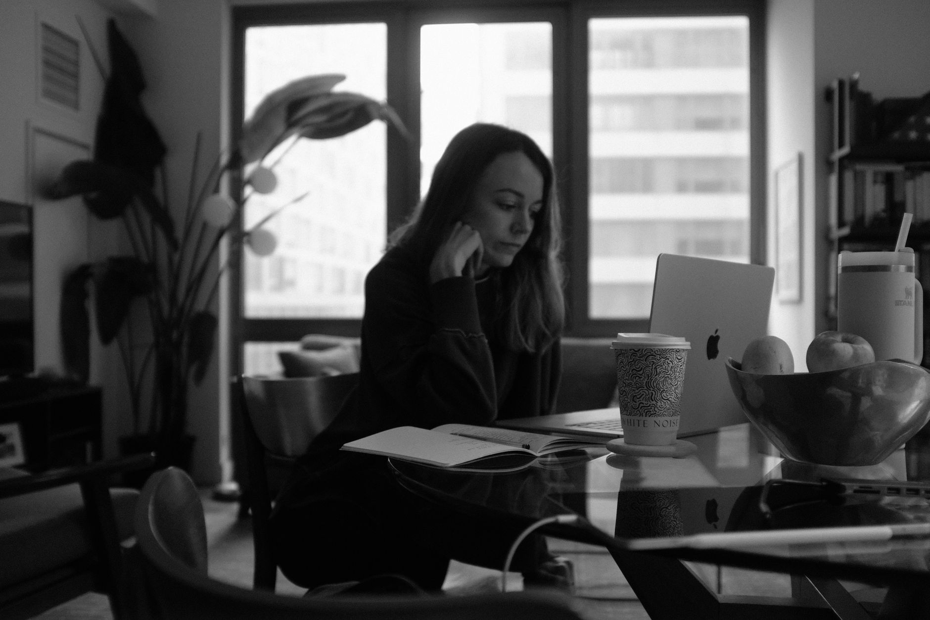 自宅でコーヒーを飲みながら勉強する女性