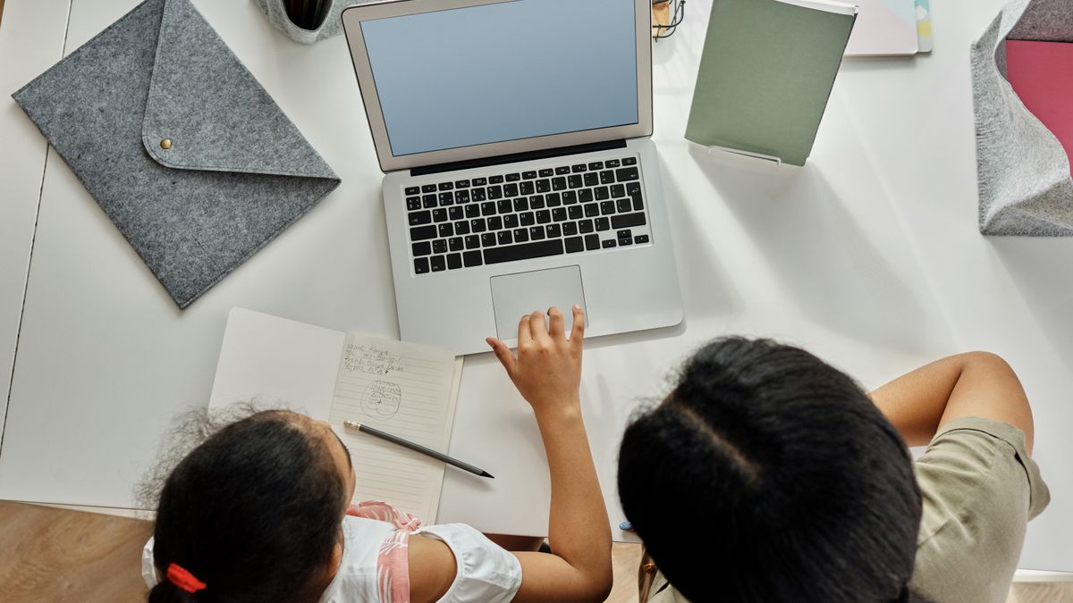 mother studying at home at night with laptop and notebook