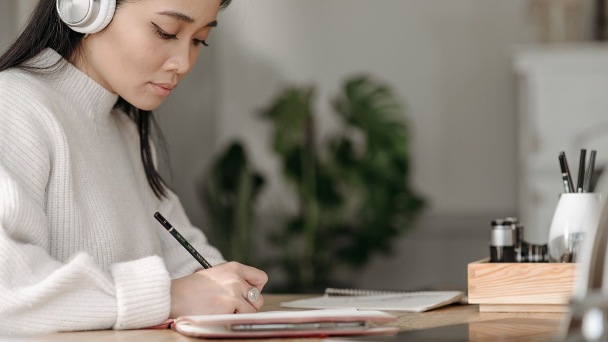 person practicing english shadowing with headphones at desk