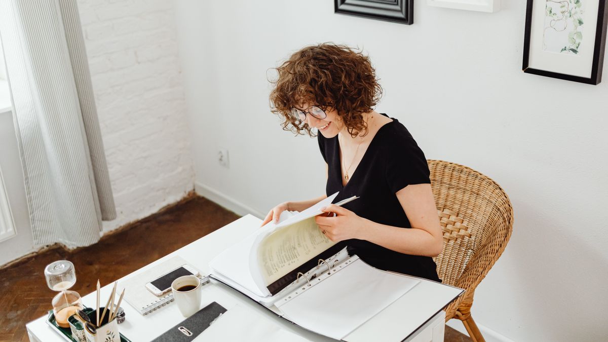 woman office worker smiling at desk with documents