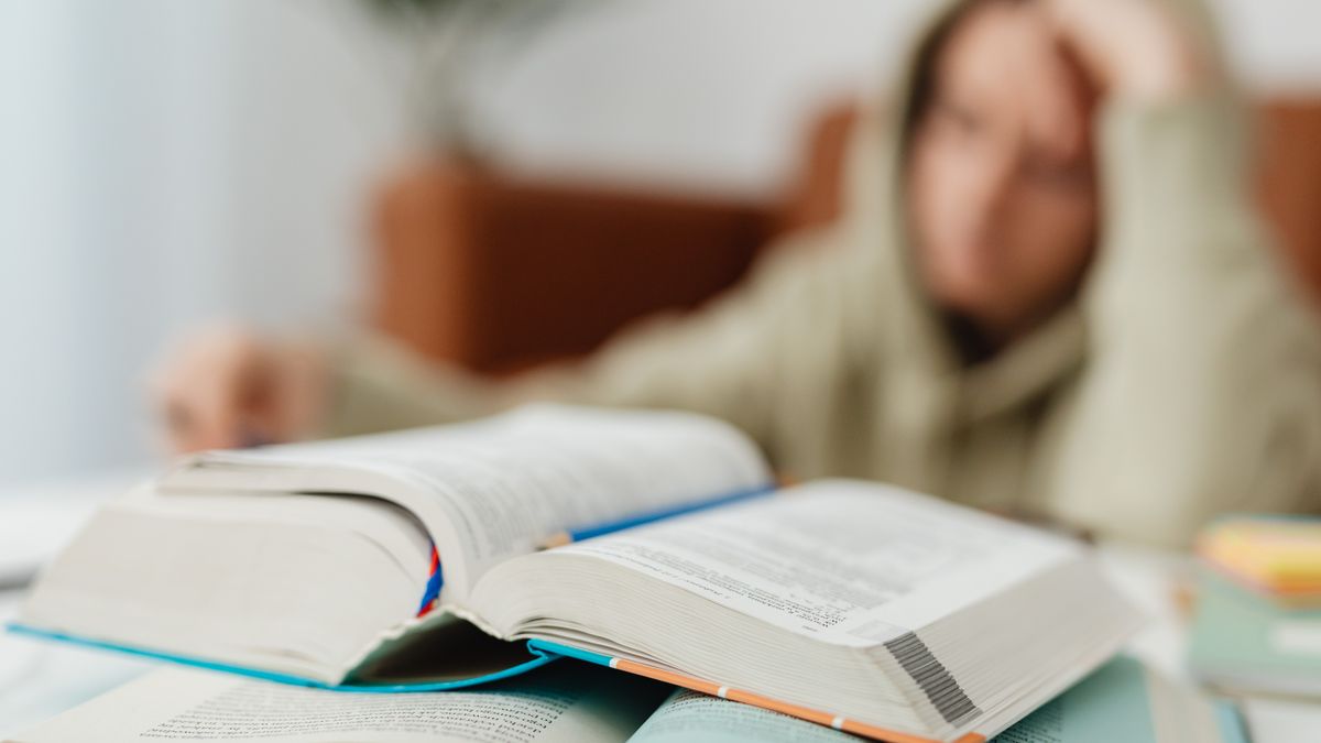 夜遅くに参考書を使って一人で勉強する人