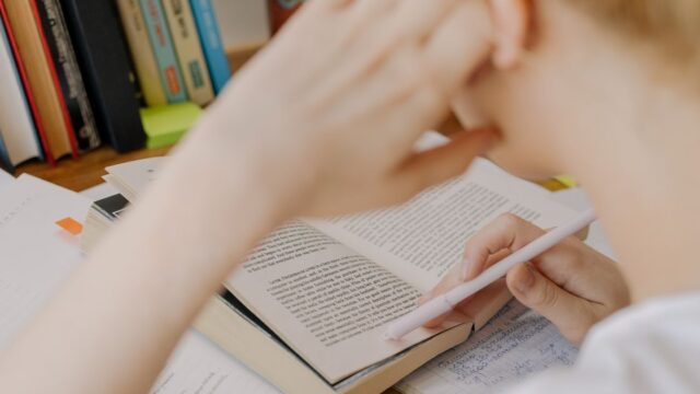 社労士試験に向けて夜遅くまで参考書で独学する人