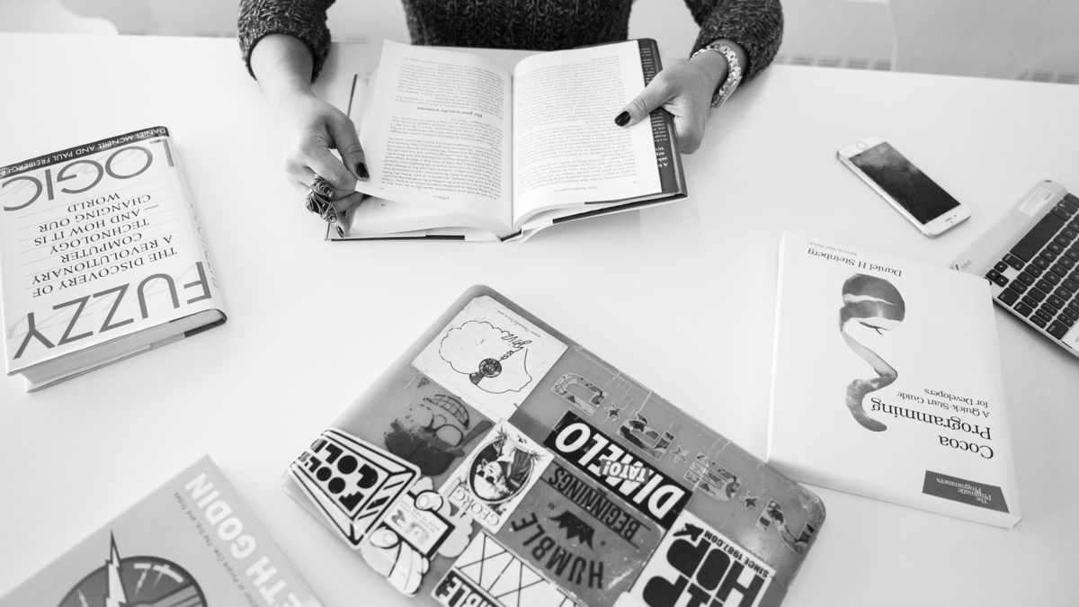 woman studying programming book at desk