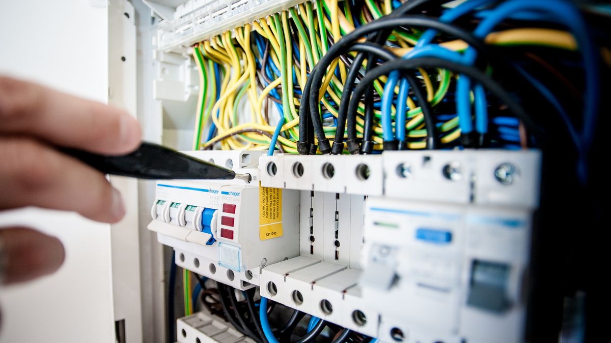 electrician installing wiring panel indoor