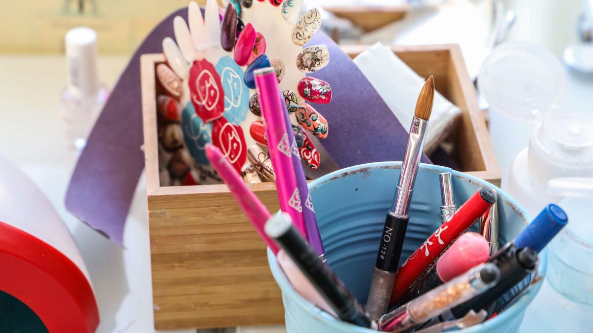 woman practicing nail art at home desk