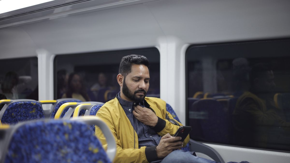 commuter studying on smartphone on train