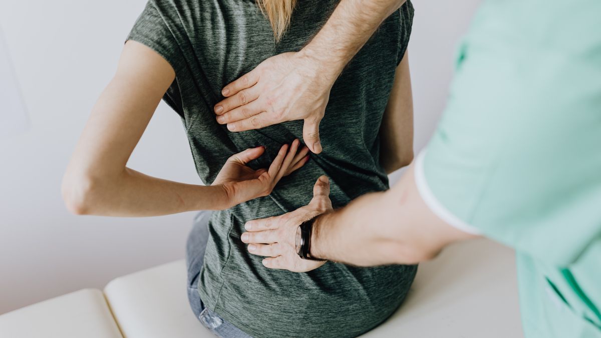 physical therapist massaging patient back clinic