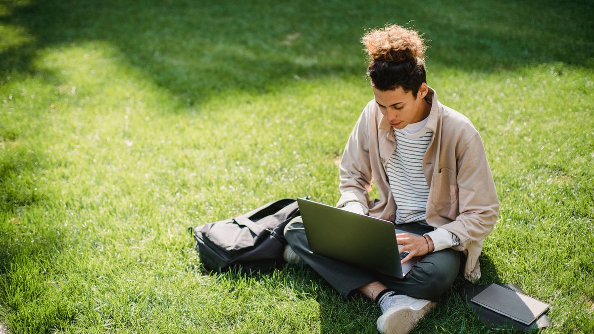 student checking university course catalog with laptop