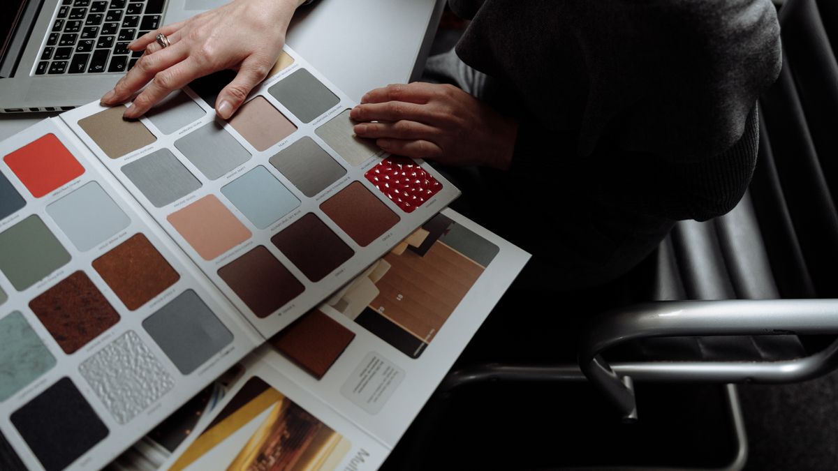 woman studying color swatches home desk