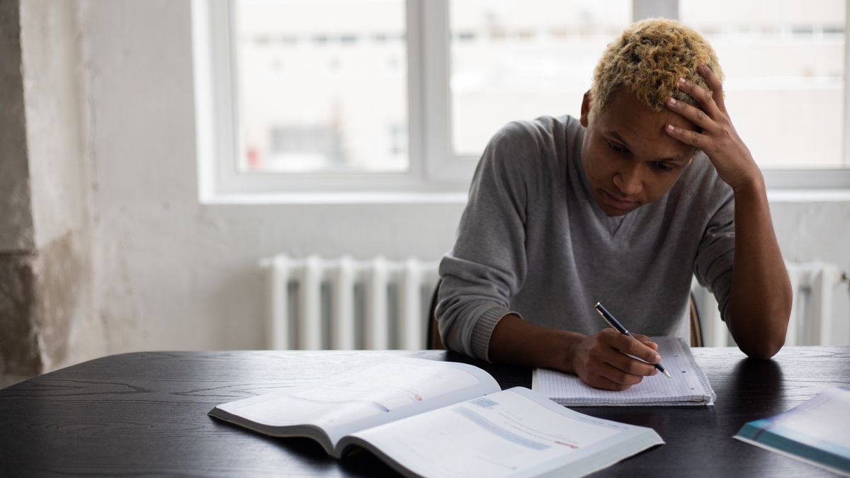 student studying textbooks confused expression