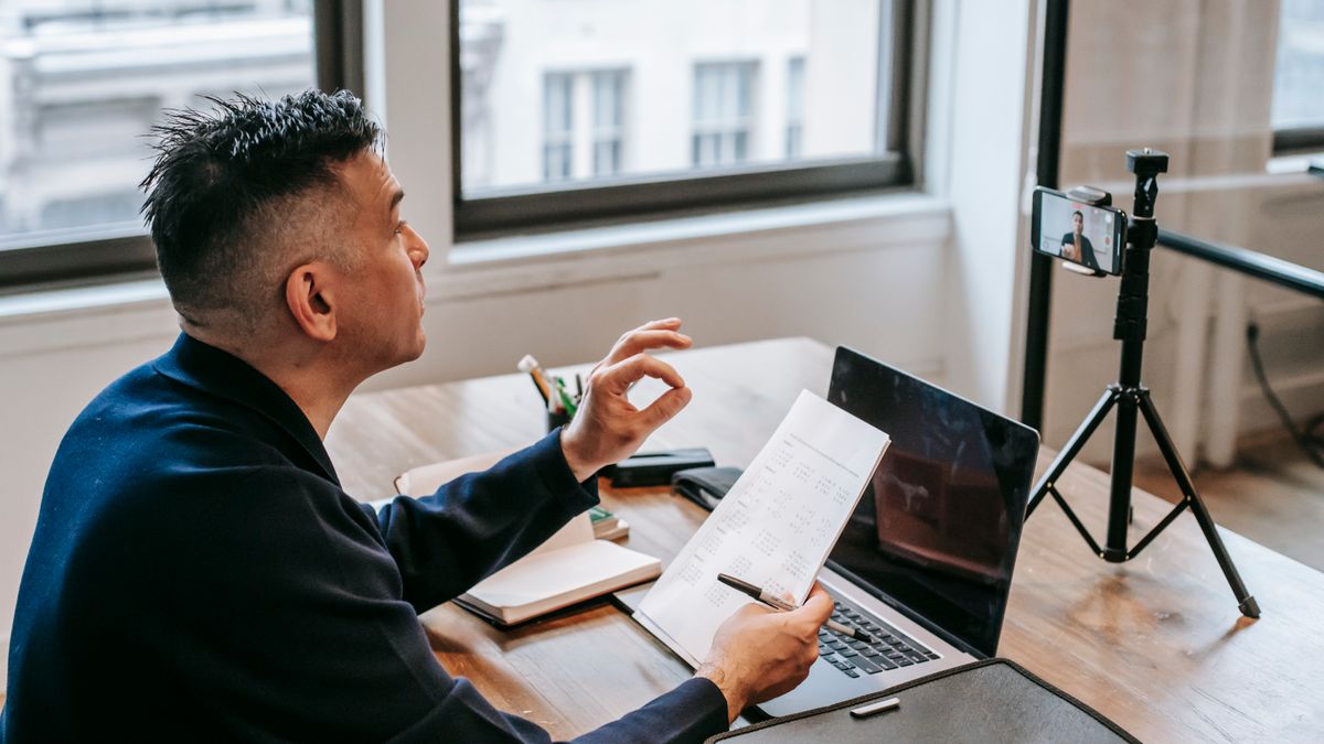 person watching online video lecture on laptop smartphone