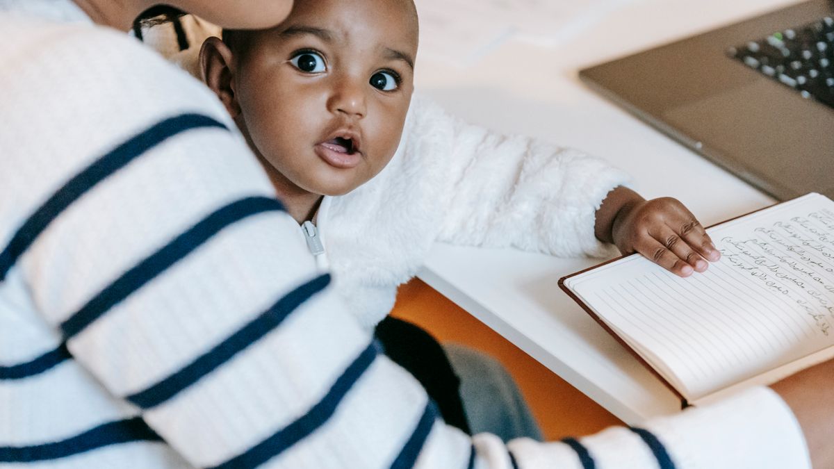 woman studying at home with baby nearby