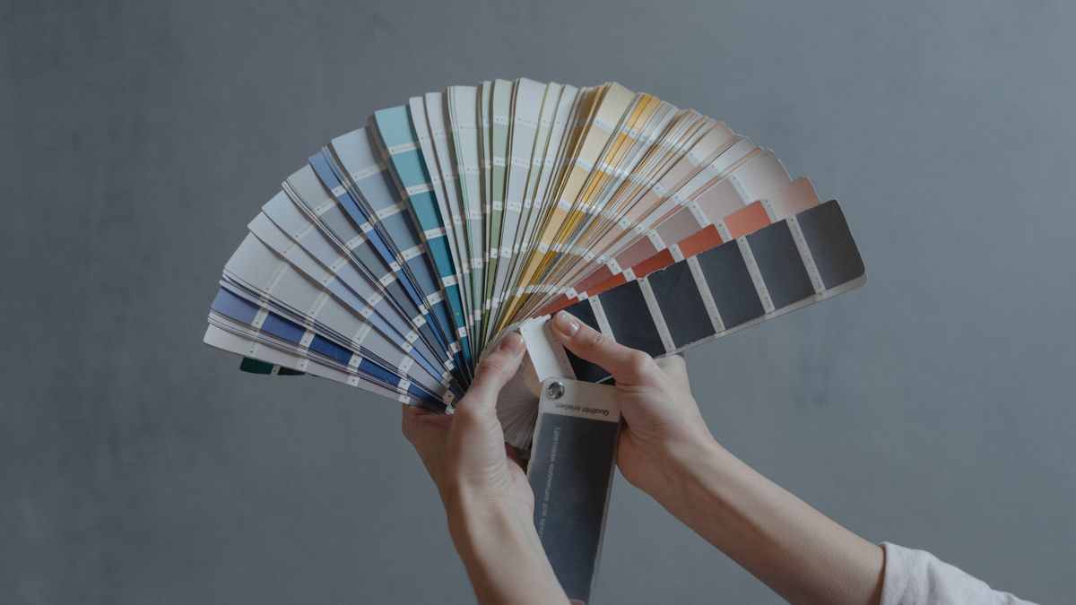 person choosing color swatches for interior design