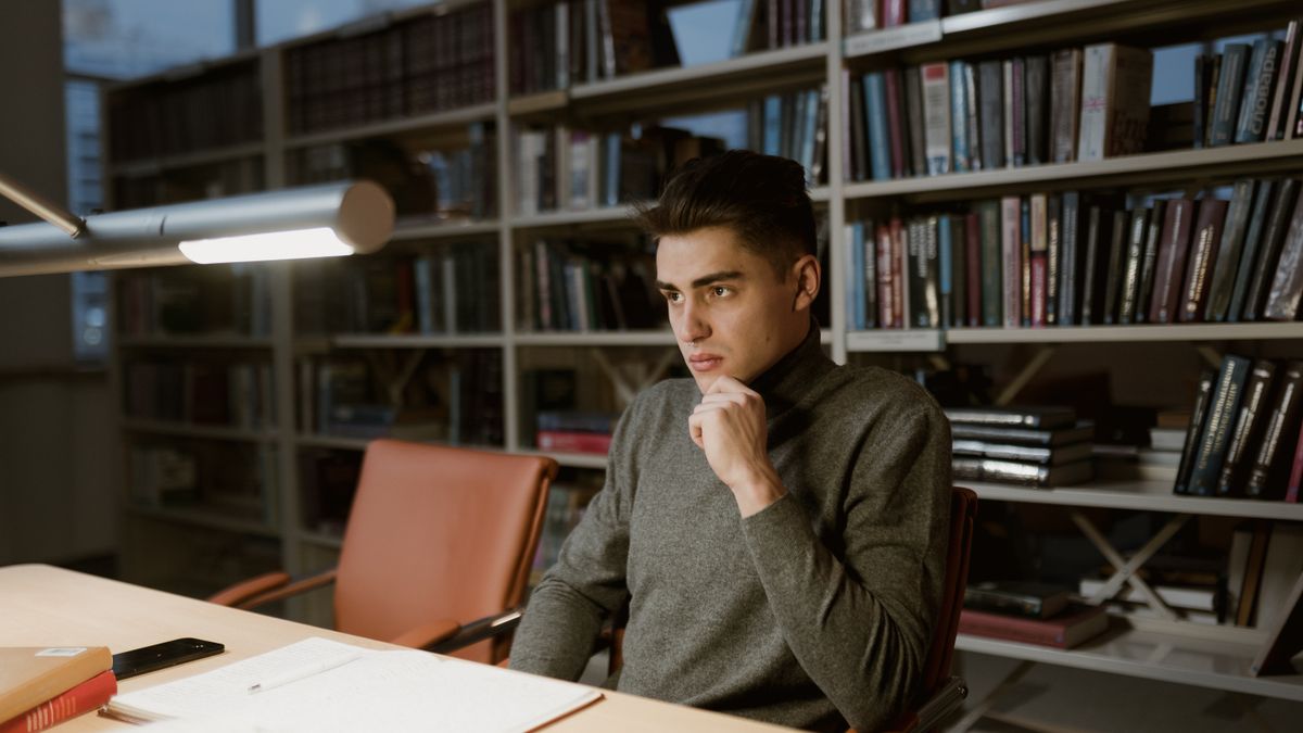 man studying desk lamp evening home