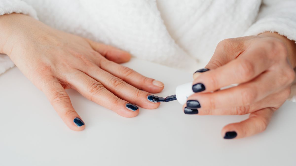hands practicing nail polish application on practice tip