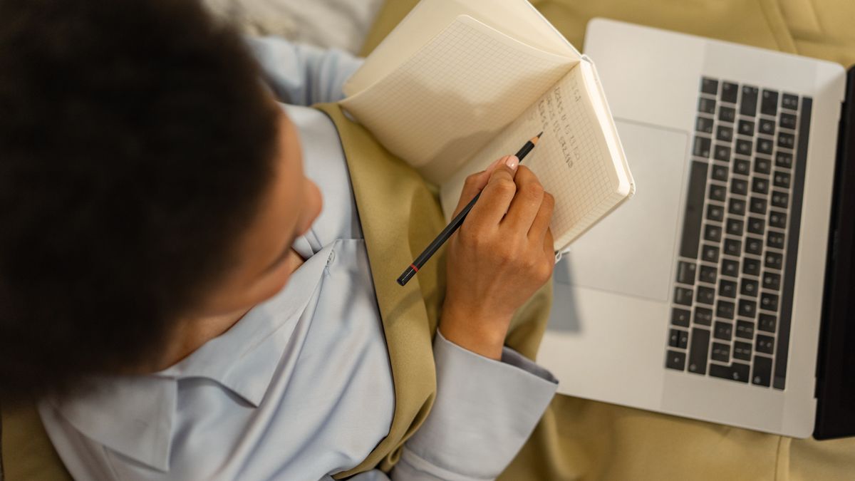 woman studying online course laptop notes
