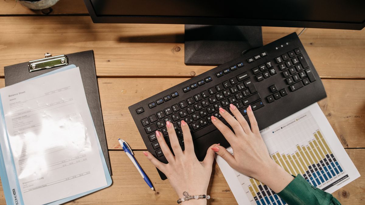 hands typing laptop spreadsheet data analysis