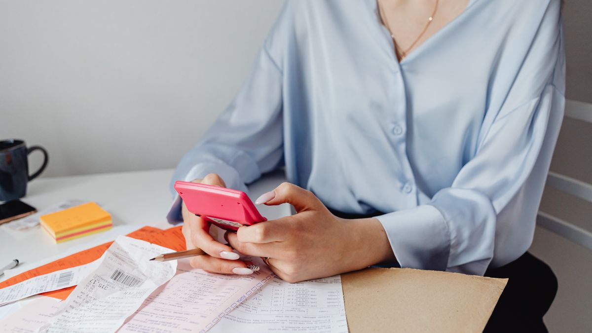 person calculating budget calculator course brochures