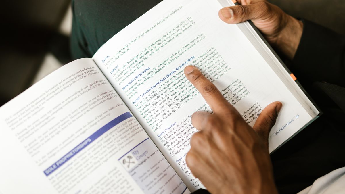 person studying real estate law textbook at desk