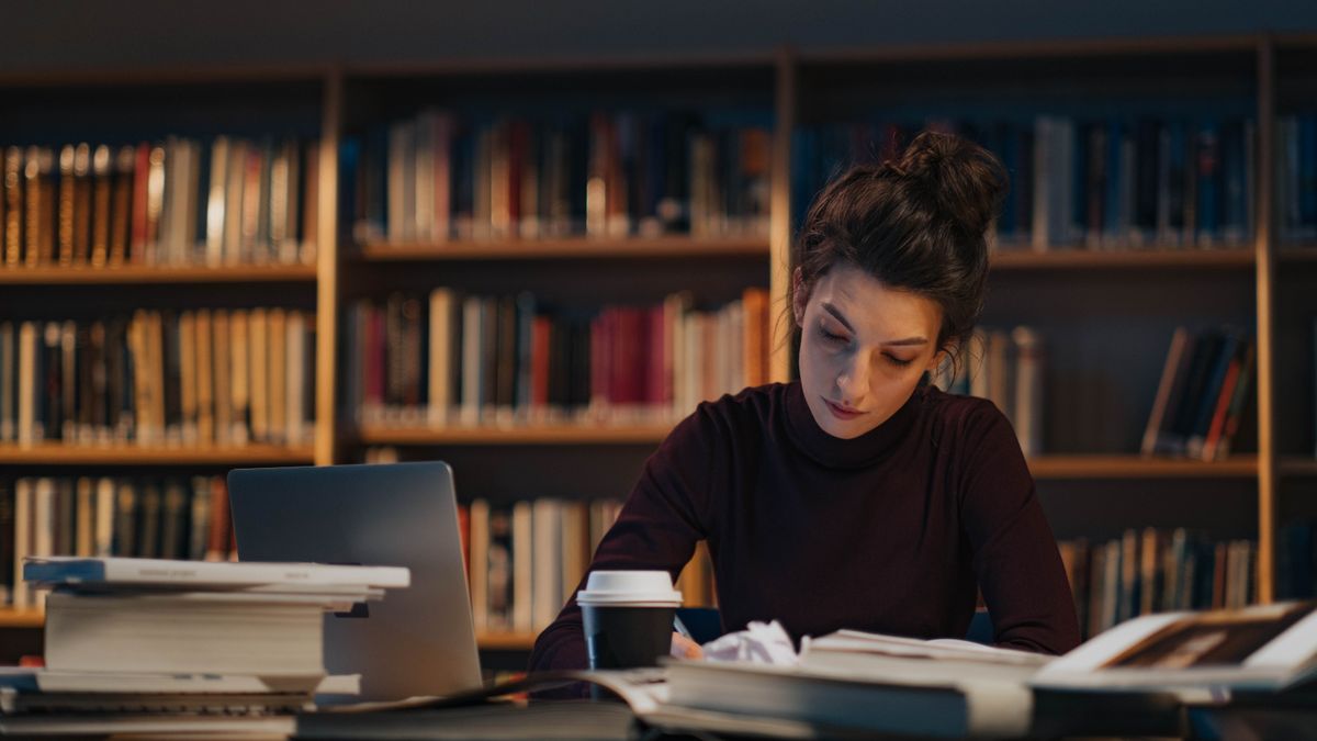 person studying law textbooks desk at night