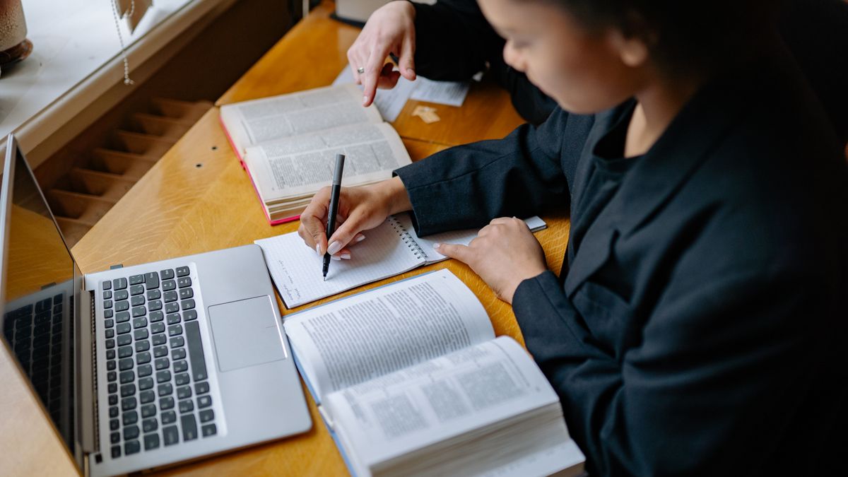 person studying laptop notes desk