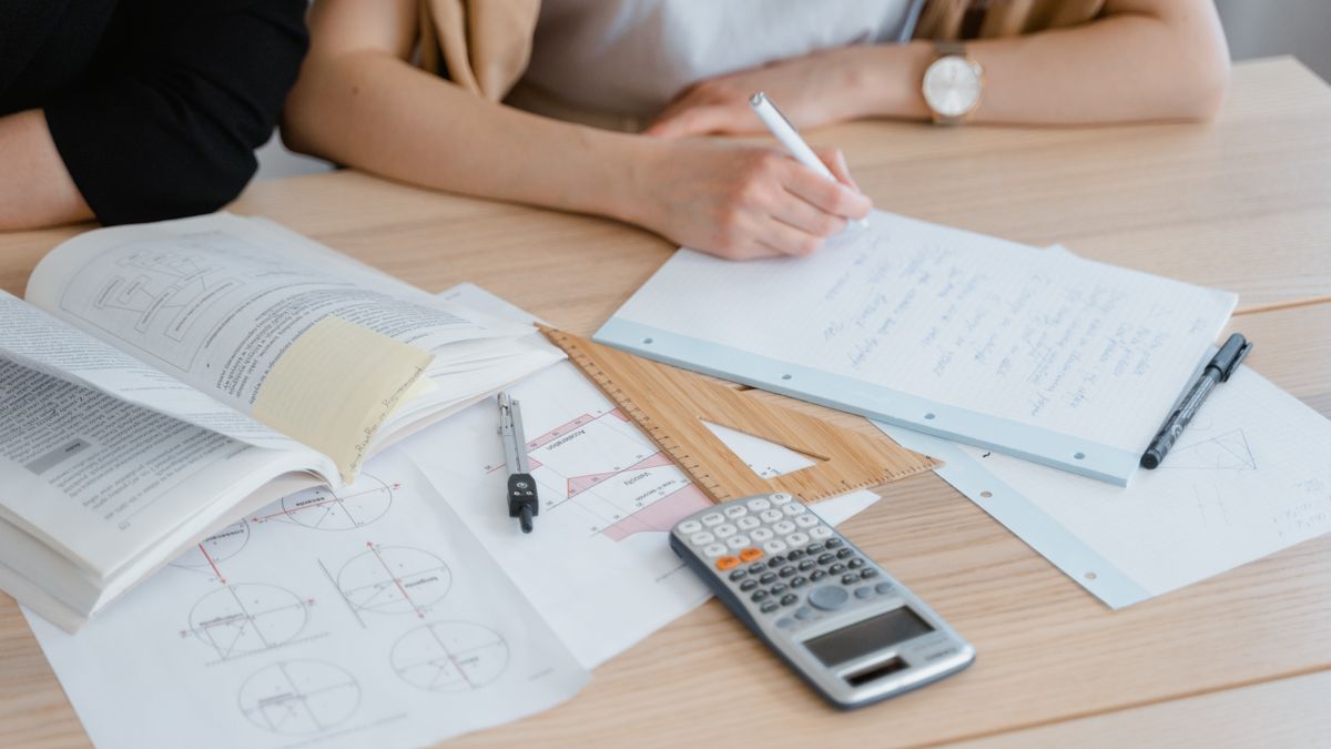 person studying electrical wiring diagram textbook desk