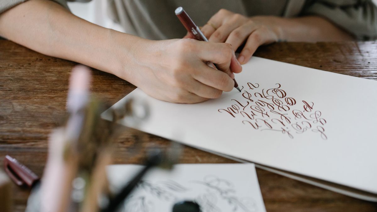 person writing hangul alphabet notebook