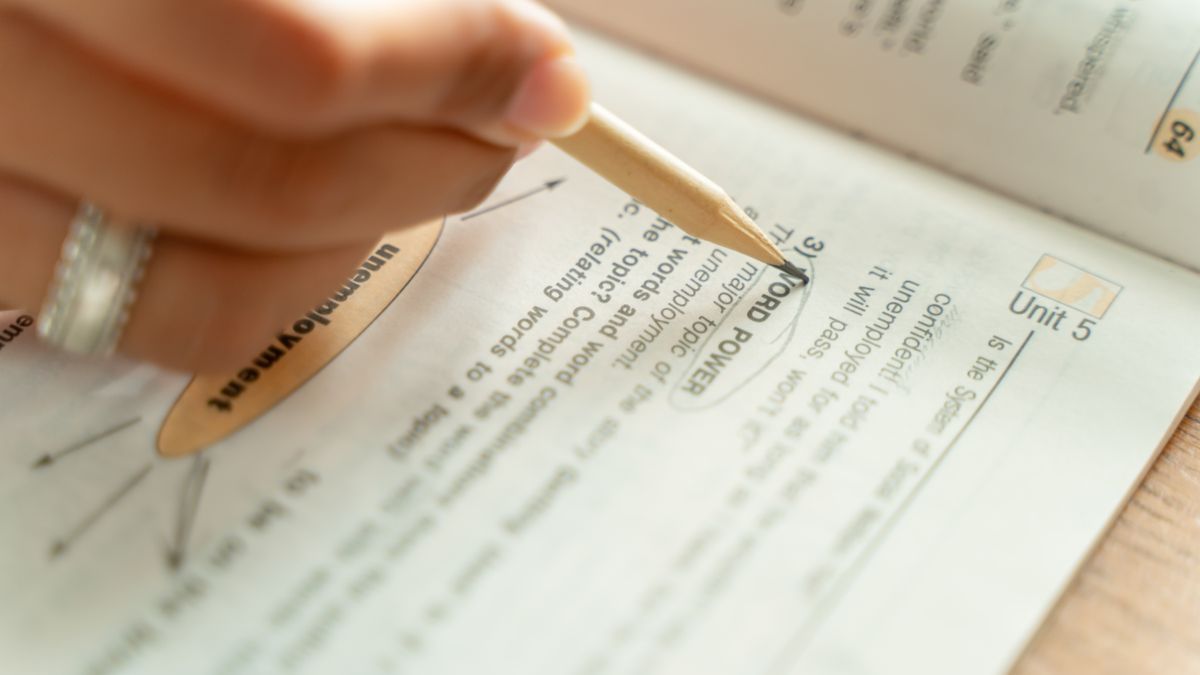 person highlighting textbook exam preparation