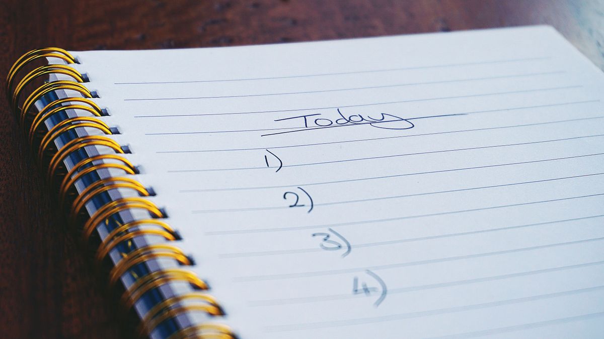 person comparing checklist notes desk