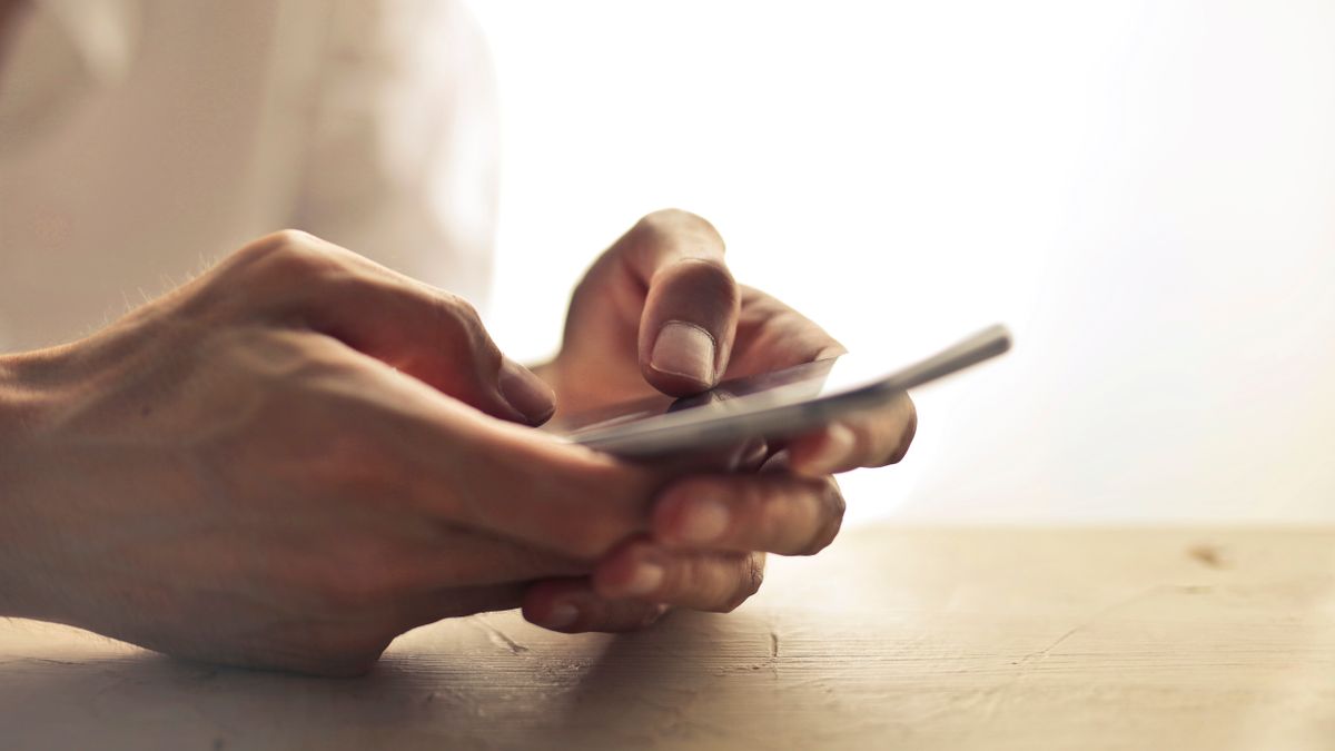 hand comparing mobile apps screen table