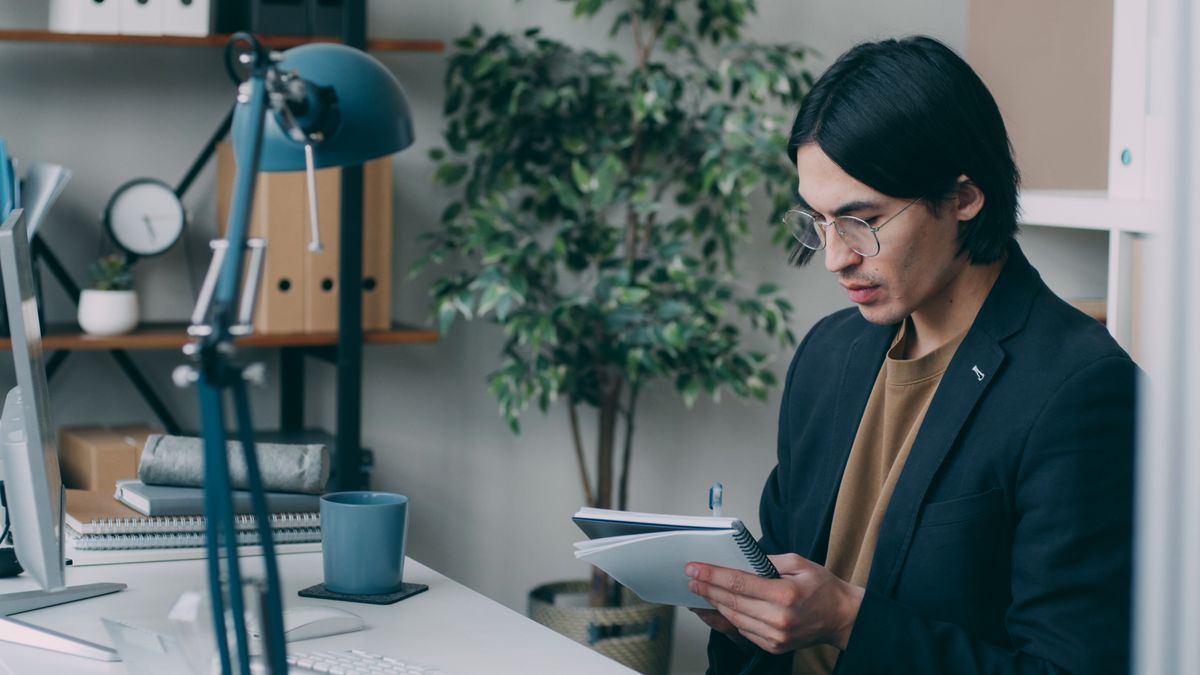 person comparing documents notebook