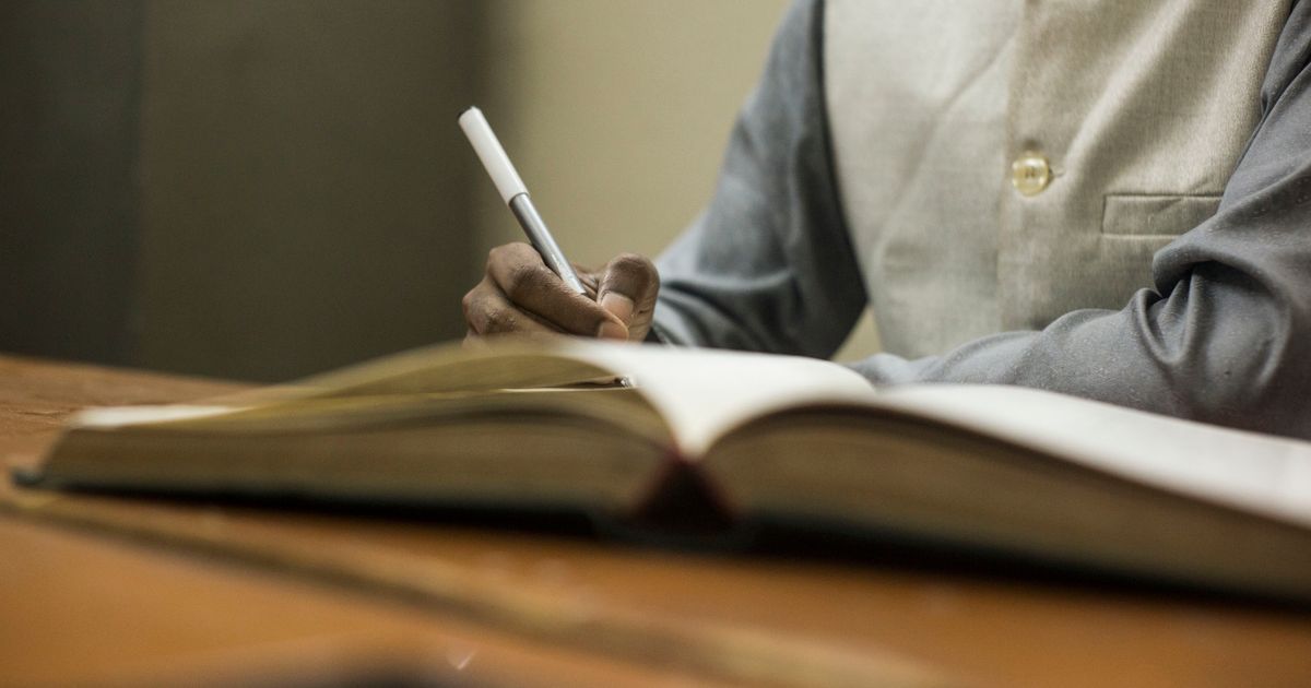 person studying textbook desk evening