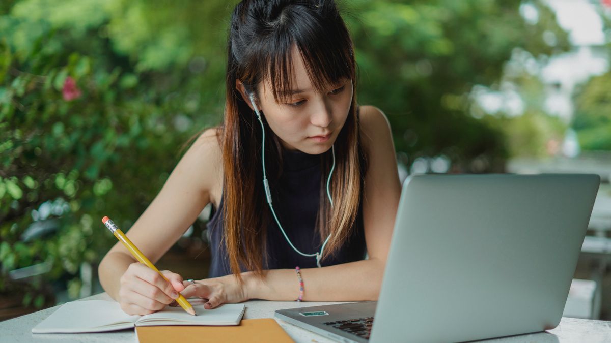 student watching online course laptop notes