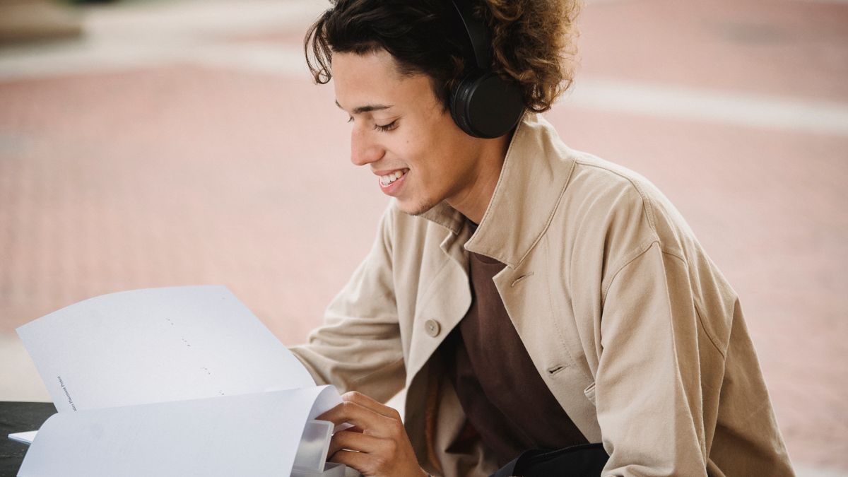 student studying with headphones textbook