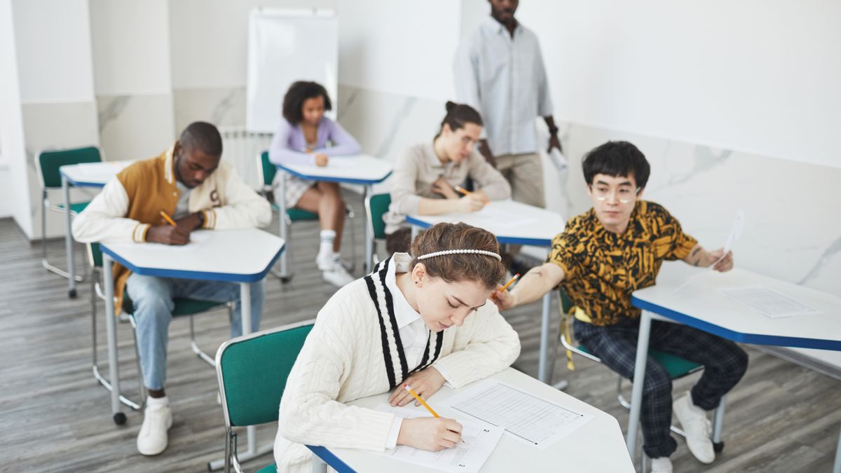 students taking exam in classroom, desk
