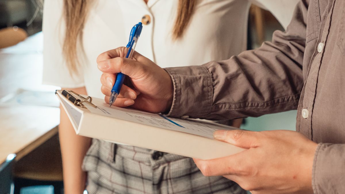 person reviewing checklist notebook pen