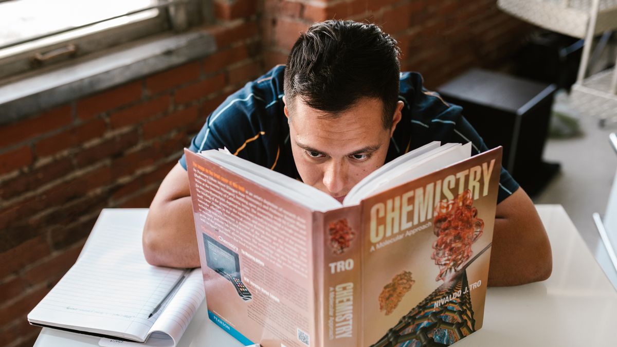 person studying nutrition textbook at desk