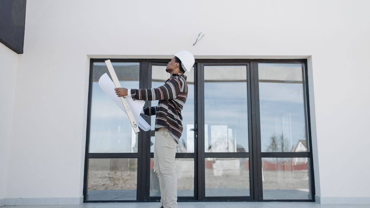 architect reviewing blueprint housing plan