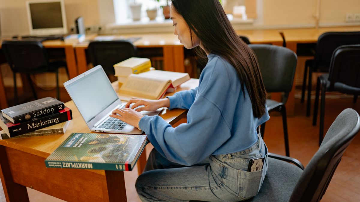 student registering for exam online with laptop