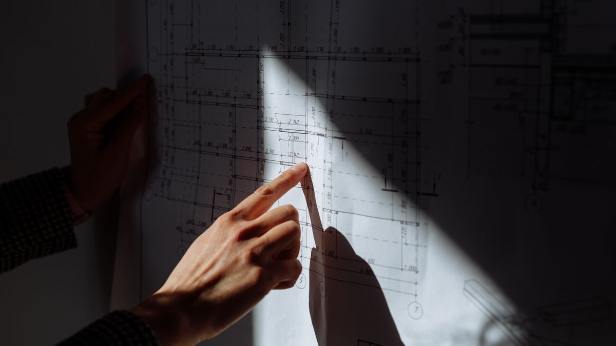 construction supervisor studying architectural drawing night