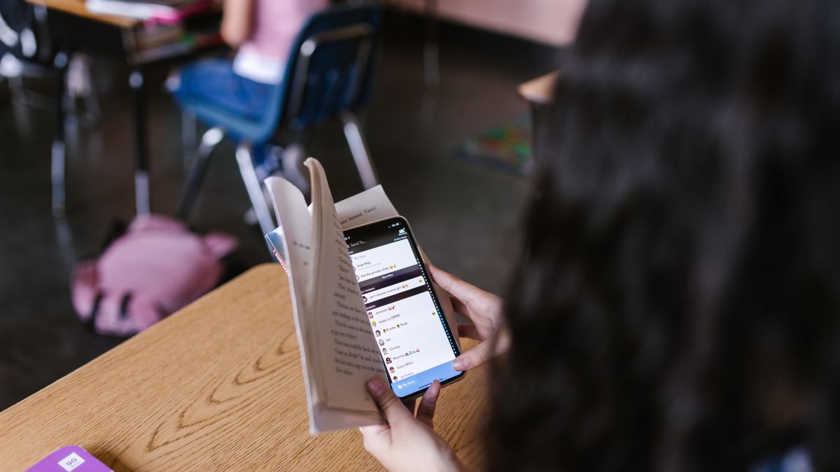 student checking toefl score smartphone night