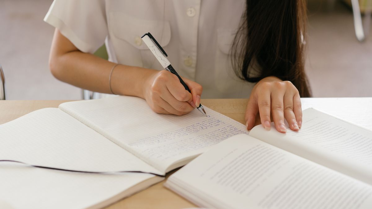person studying spanish textbook notebook