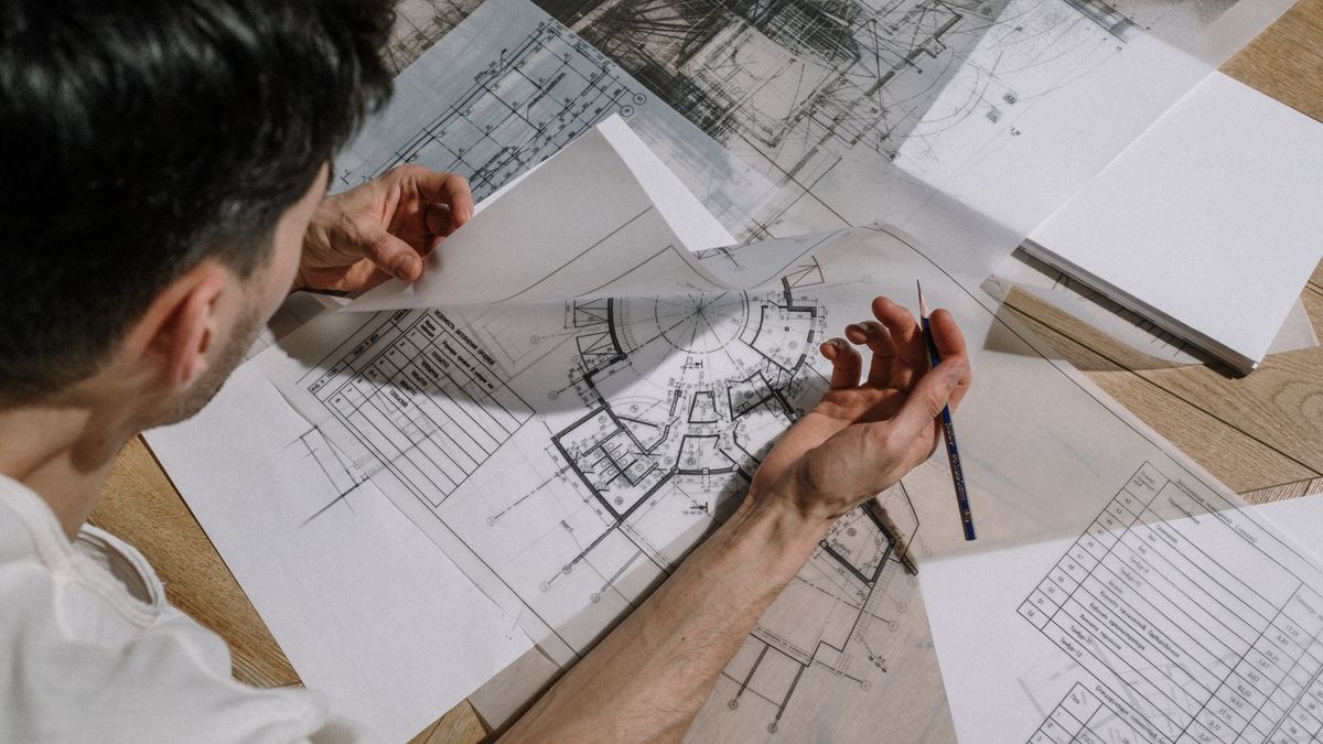 architect reviewing blueprint at construction site