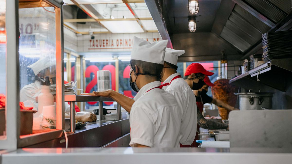 cook studying notebook in restaurant kitchen
