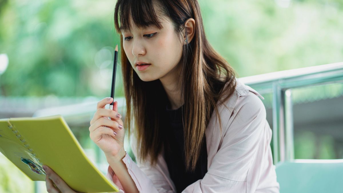 woman studying notebook in cafe
