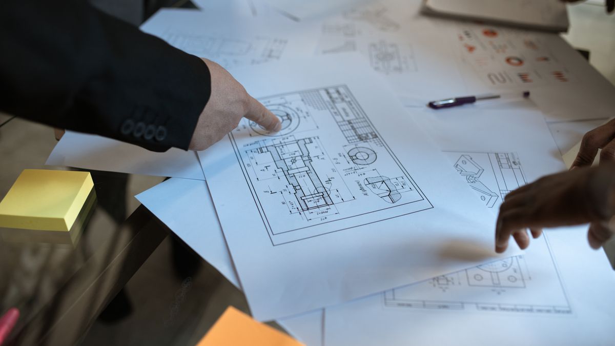 architect reviewing blueprints at office desk